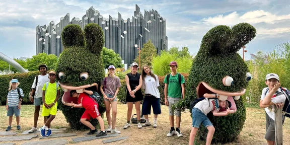 Campers posing with the giant topiary animal sculptures in the park gardens